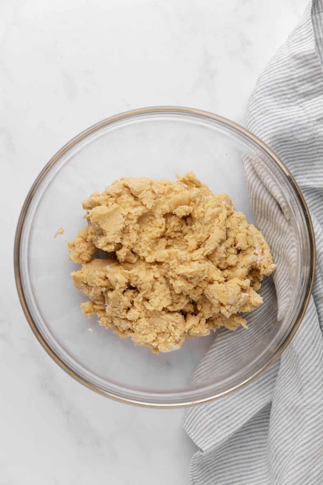 Soft vanilla sugar cookie dough mixed in a glass mixing bowl set on a flat surface.