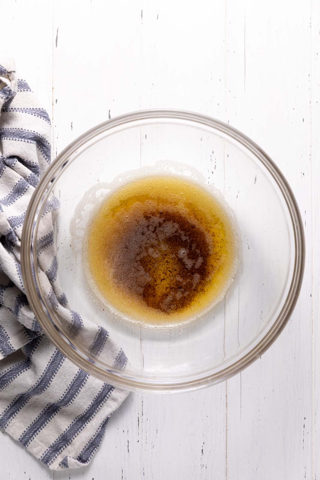 Browned butter in a glass mixing bowl set on a flat surface.