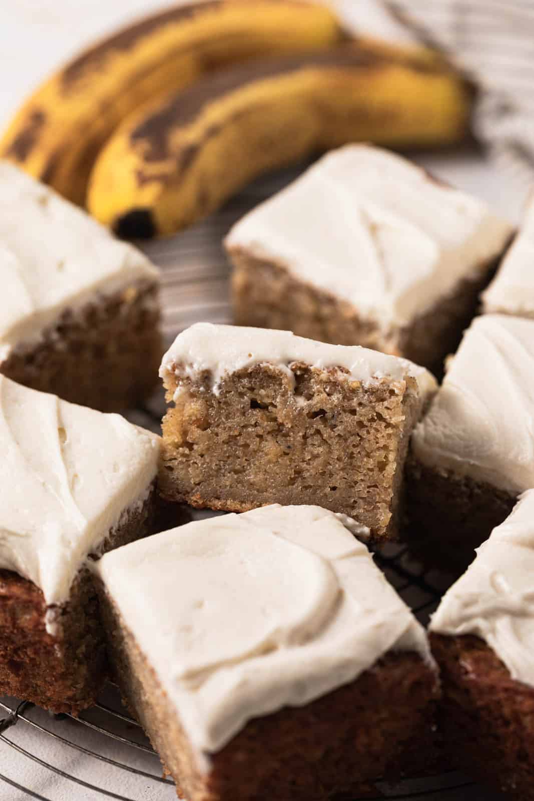 Close up of slice of banana snack cake set on a round wire rack.