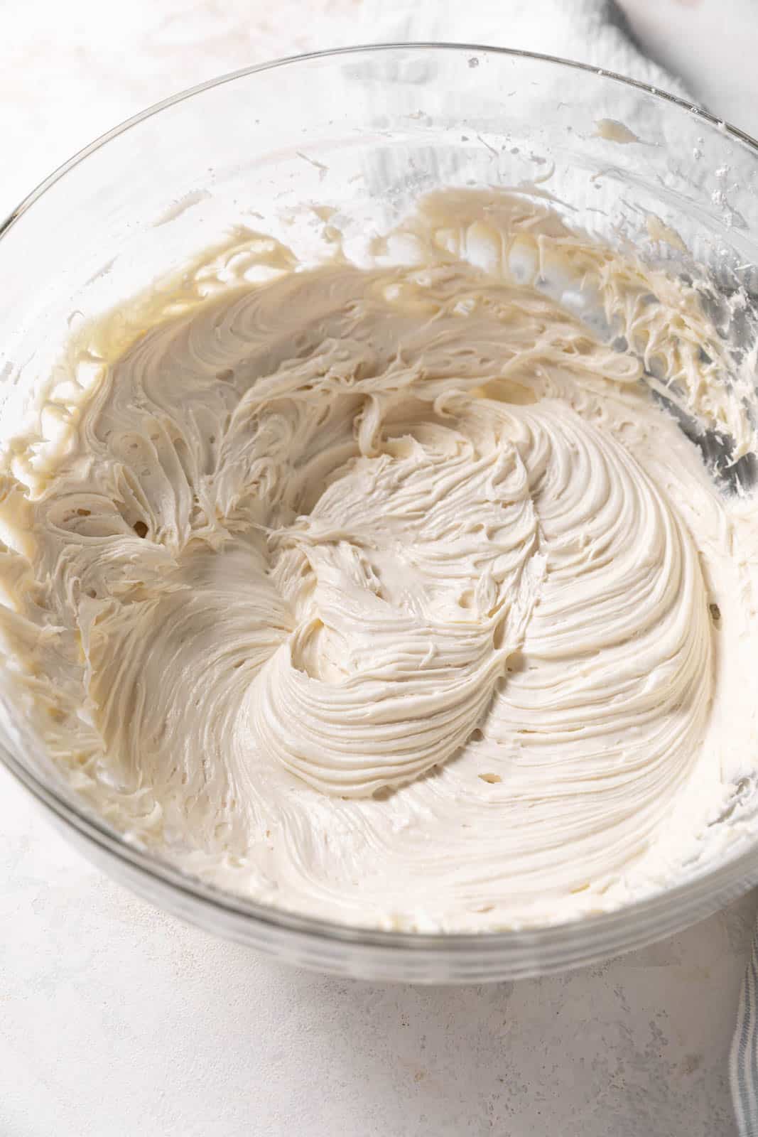 Close up of brown sugar cream cheese frosting in a glass mixing bowl.
