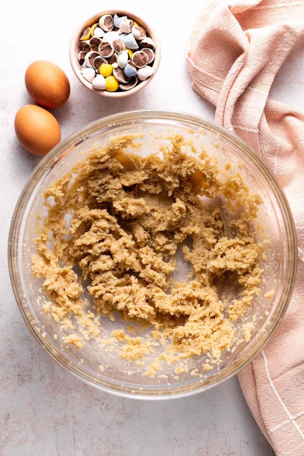 Creamed butter and sugar in a glass mixing bowl set on a flat surface.