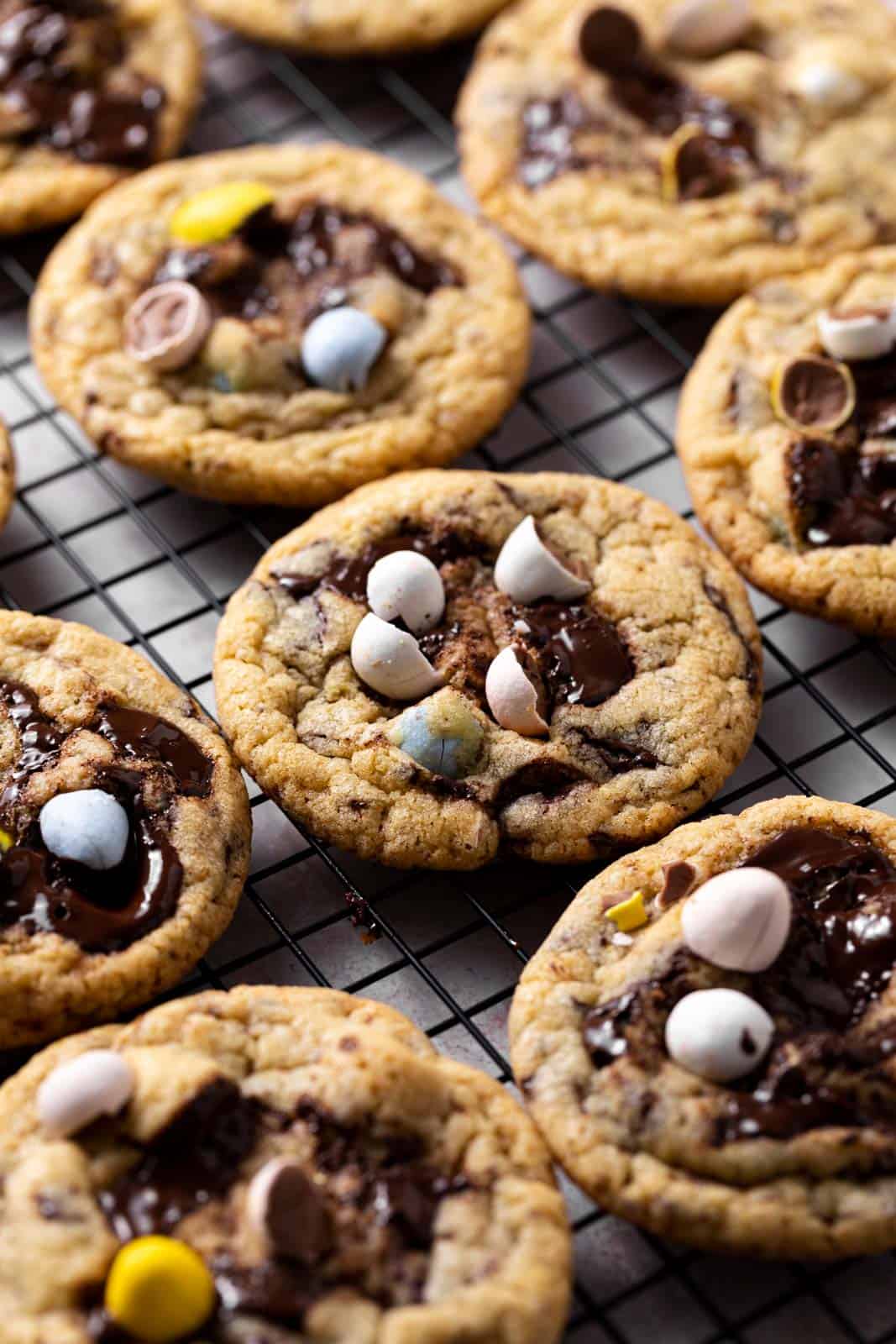 Close of up baked mini egg cookies set on a black wire rack.
