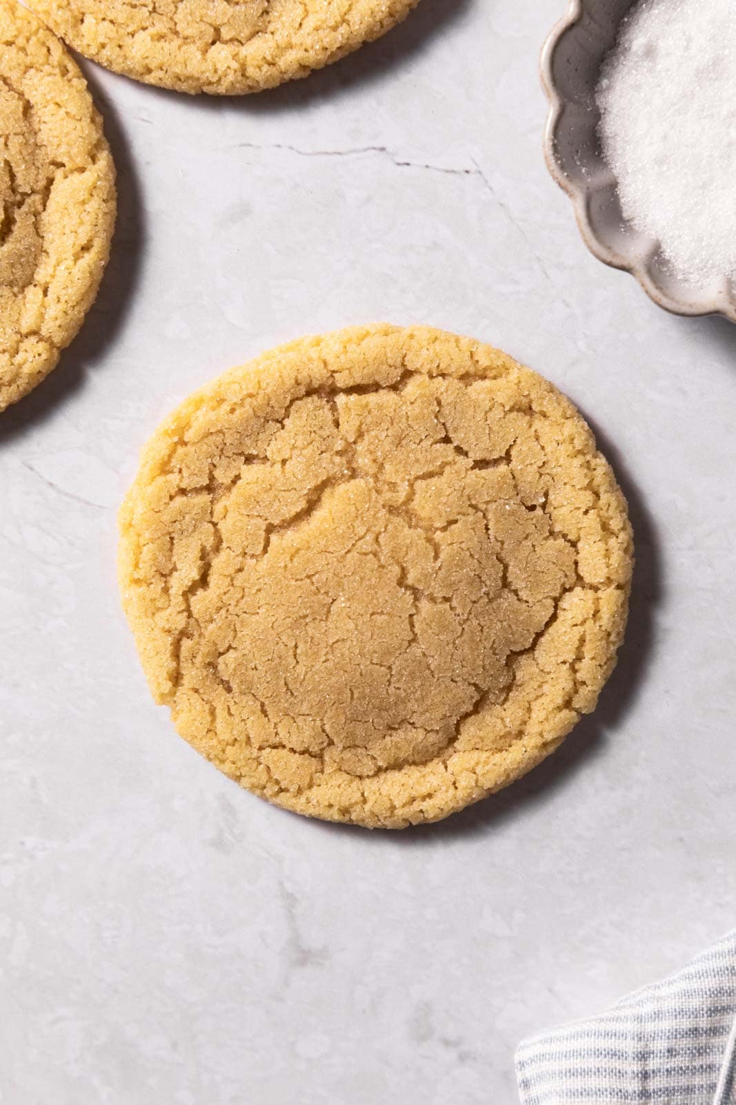 Close up of a small batch sugar cookie on a flat white surface.