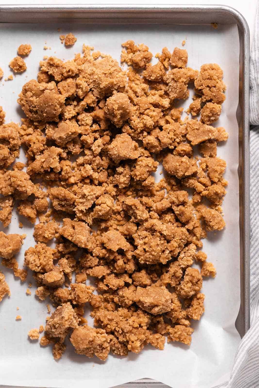 Parchment lined sheet pan with unbaked brown sugar crumble.