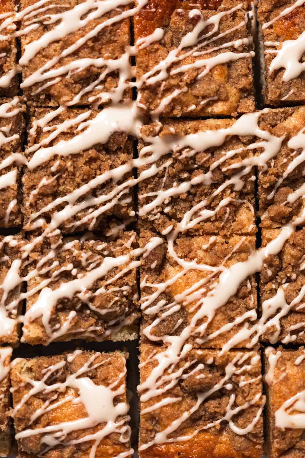 Blackberry coffee cake cut into squares and drizzled with a vanilla glaze.
