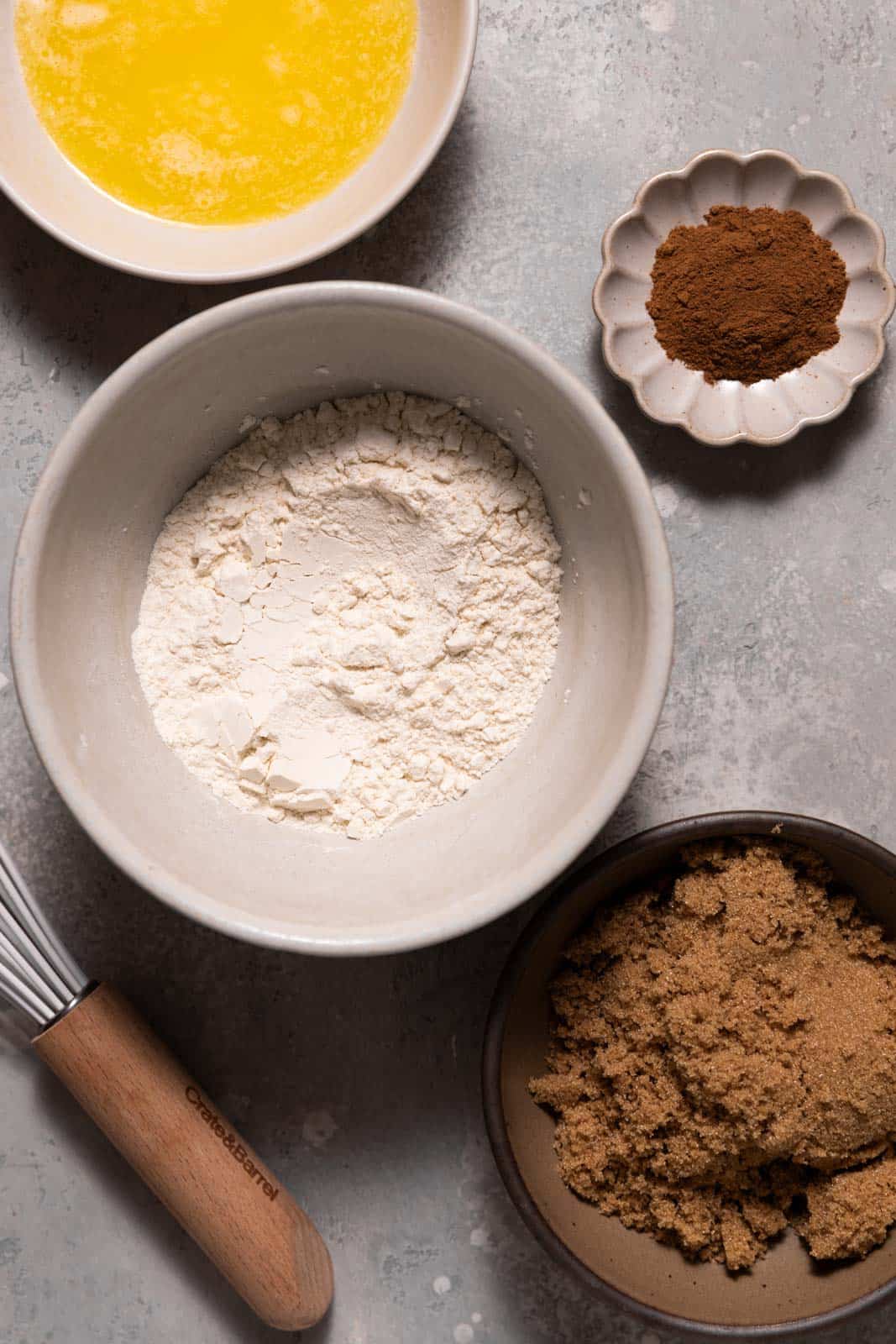 Ingredients for brown sugar crumble in a bowls set on a grey surface.