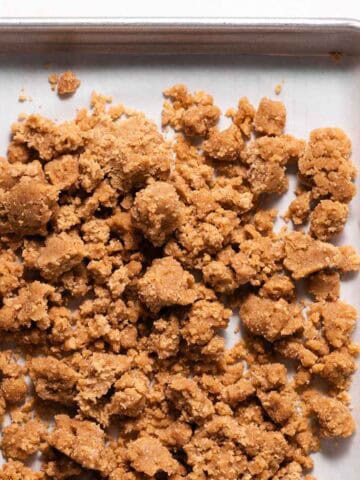 Parchment lined sheet pan with unbaked brown sugar crumble.