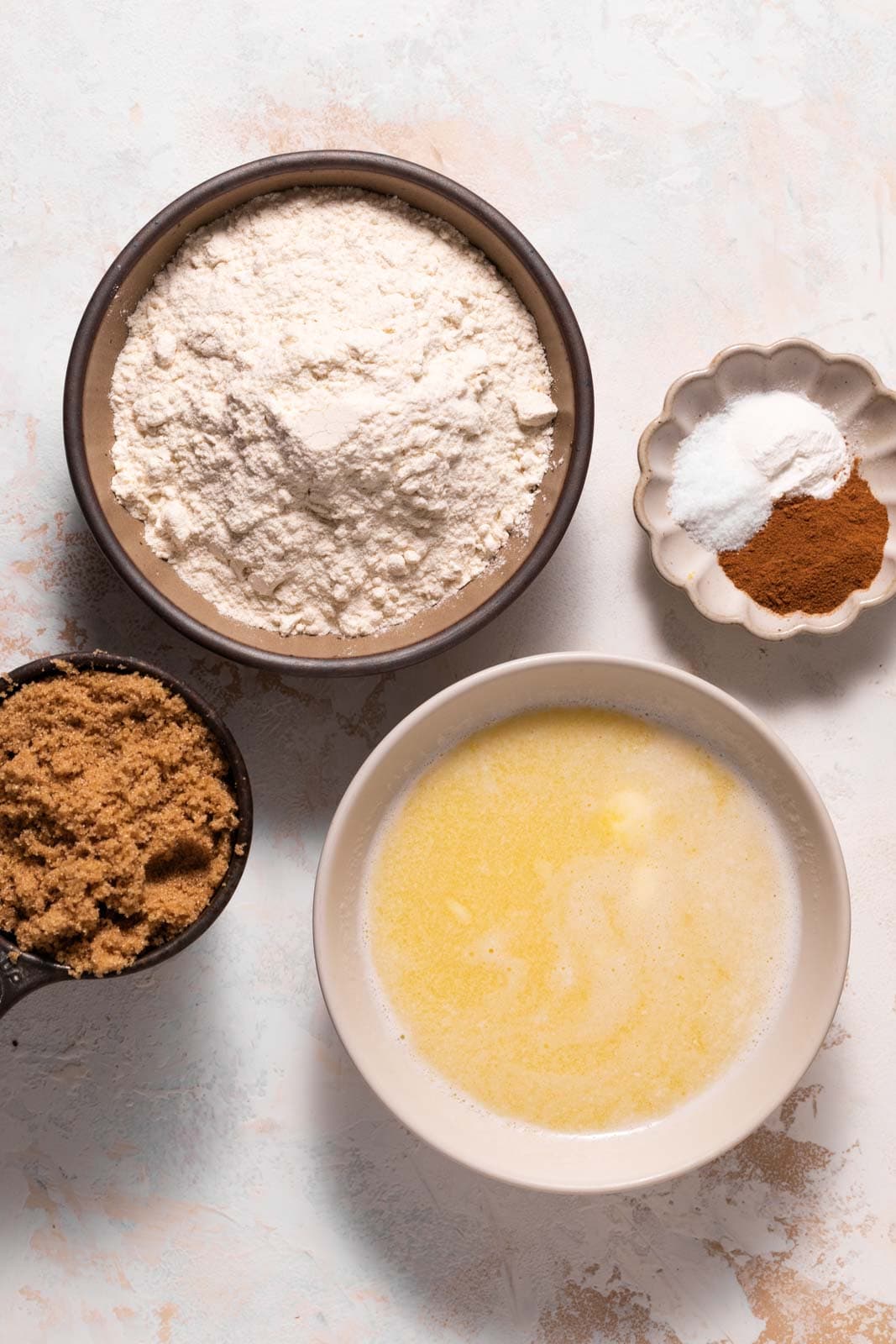 Ingredients for crumble in bowls sets on a flat white surface.