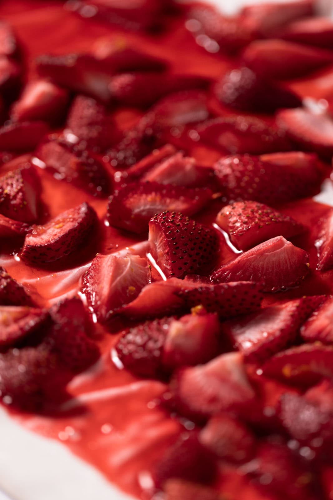 Roasted strawberries on a parchment line sheet pan.