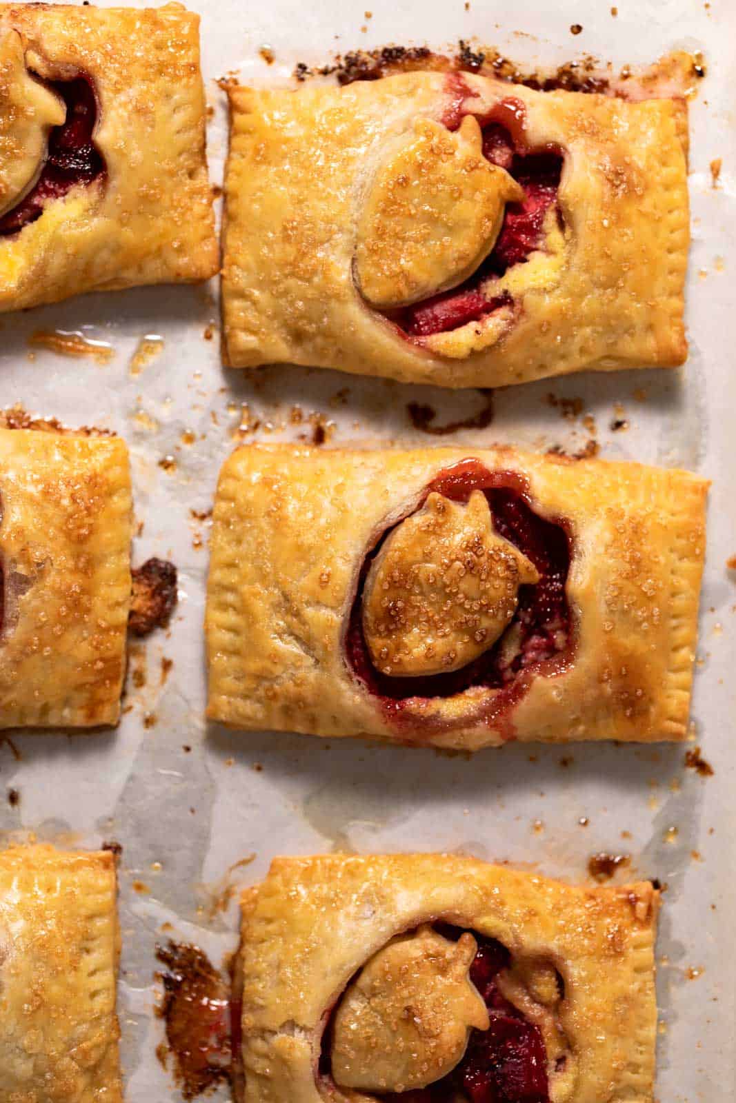 Roasted strawberry hand pies on a parchment lined sheet pan.