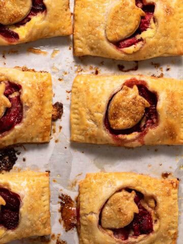 Roasted strawberry hand pies on a parchment lined sheet pan.