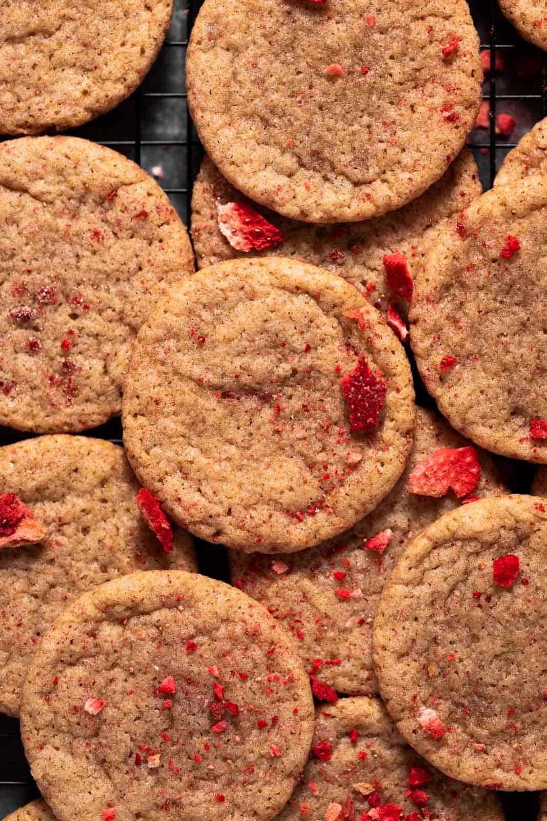 Overhead shot of strawberry sugar cookies layered on cookie rack.