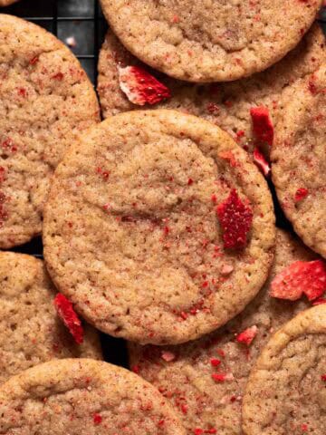 Overhead shot of strawberry sugar cookies layered on cookie rack.