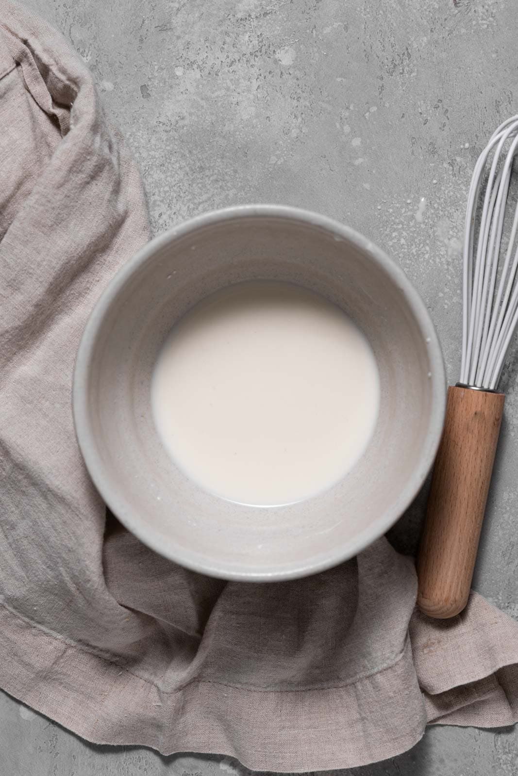 Milk and cornstarch mixed in a small white bowl.