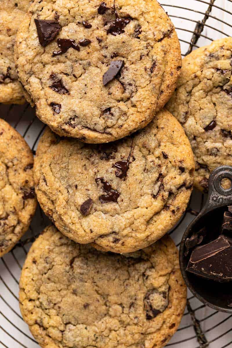 Close up overhead shot of chewy chocolate chip cookies tightly together set on a round wire rack.