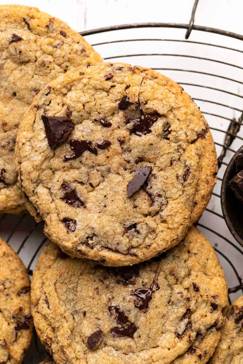Close up overhead shot of chewy chocolate chip cookies tightly together set on a round wire rack.