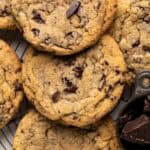 Close up overhead shot of chewy chocolate chip cookies tightly together set on a round wire rack.