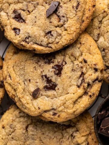 Close up overhead shot of chewy chocolate chip cookies tightly together set on a round wire rack.