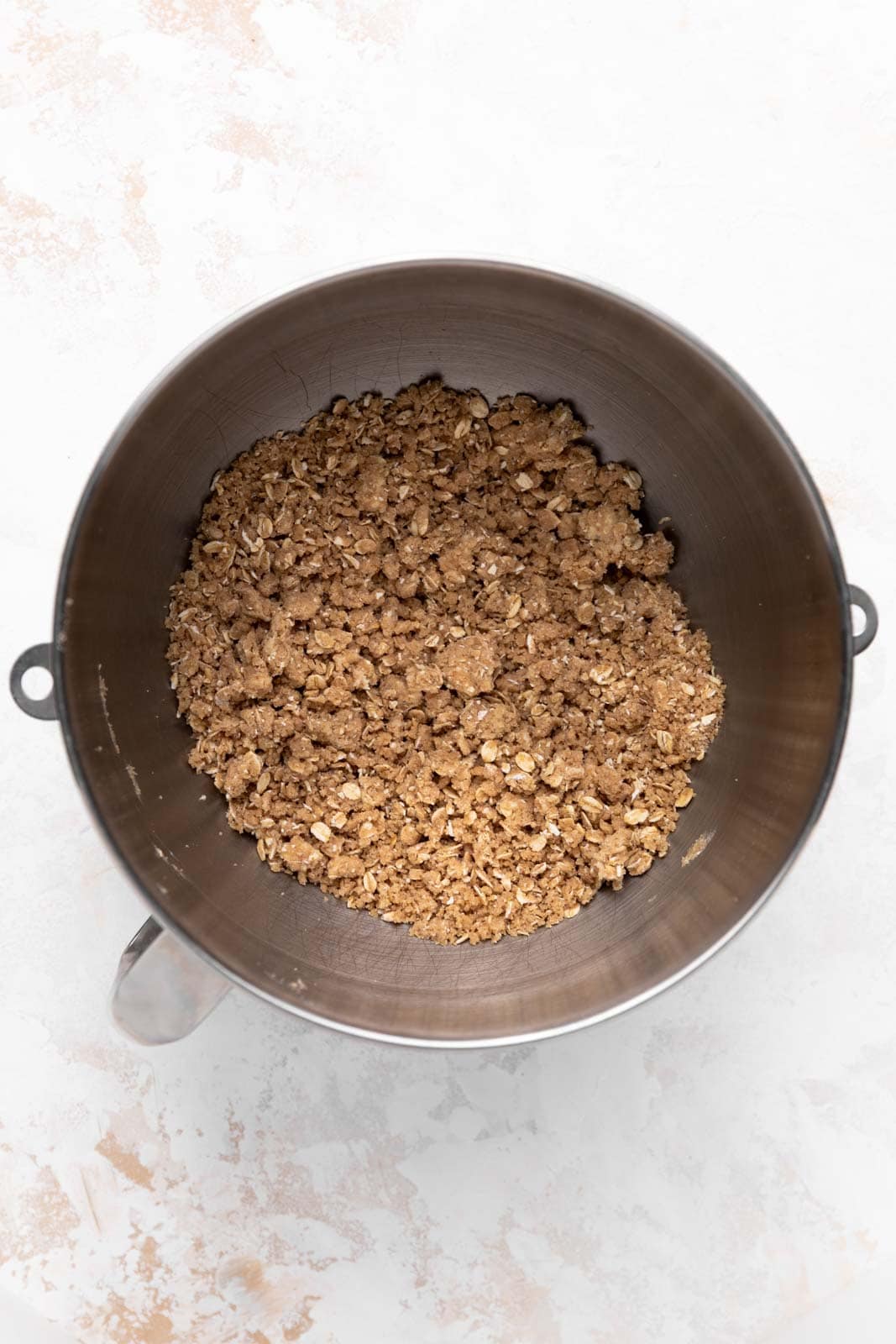 Mixed crisp topping in a metal stand mixer bowl.