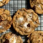 Brown butter s'mores cookies arranged flat on a black cooling rack.